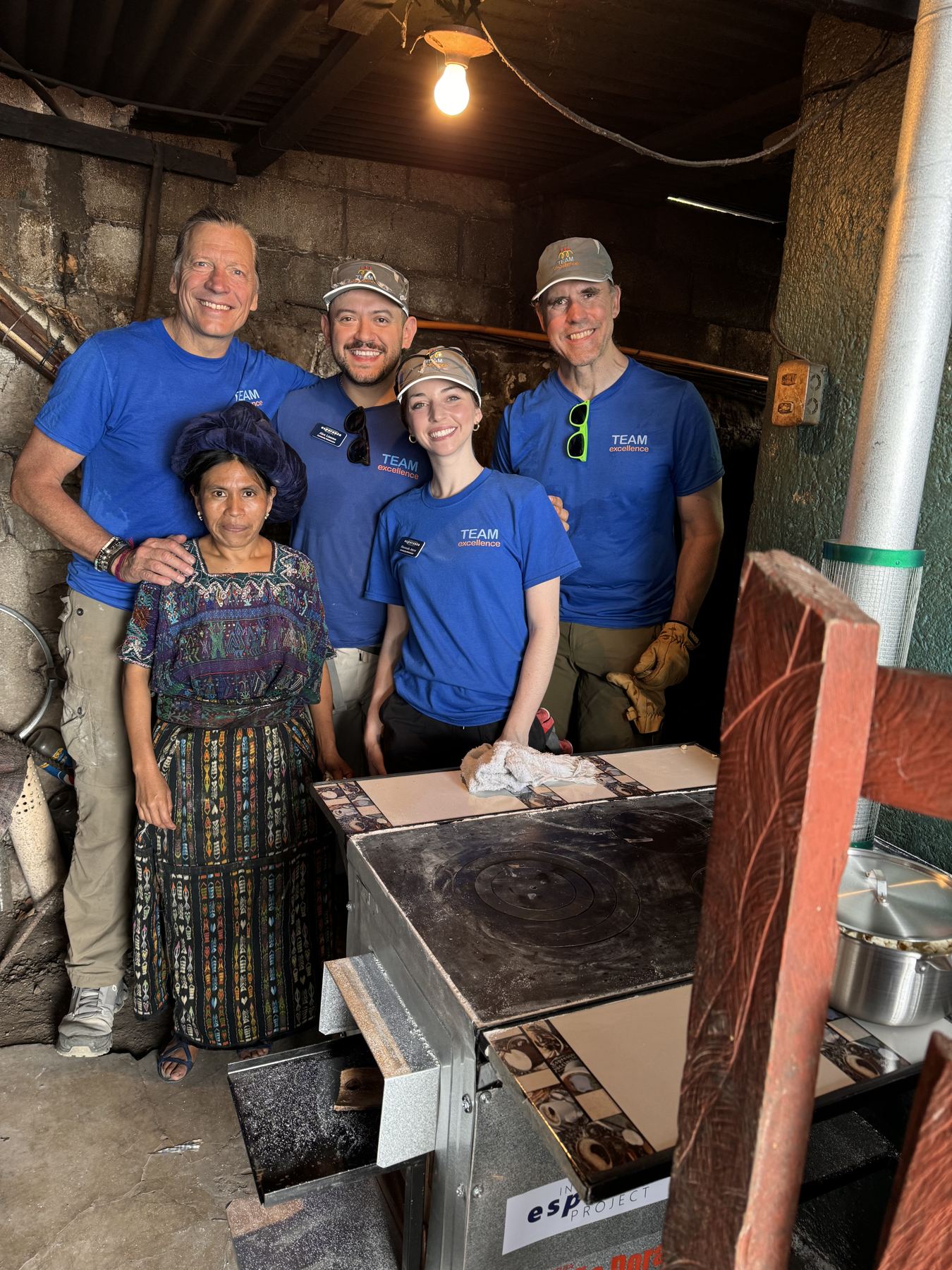Family volunteers beside a finished stove installation