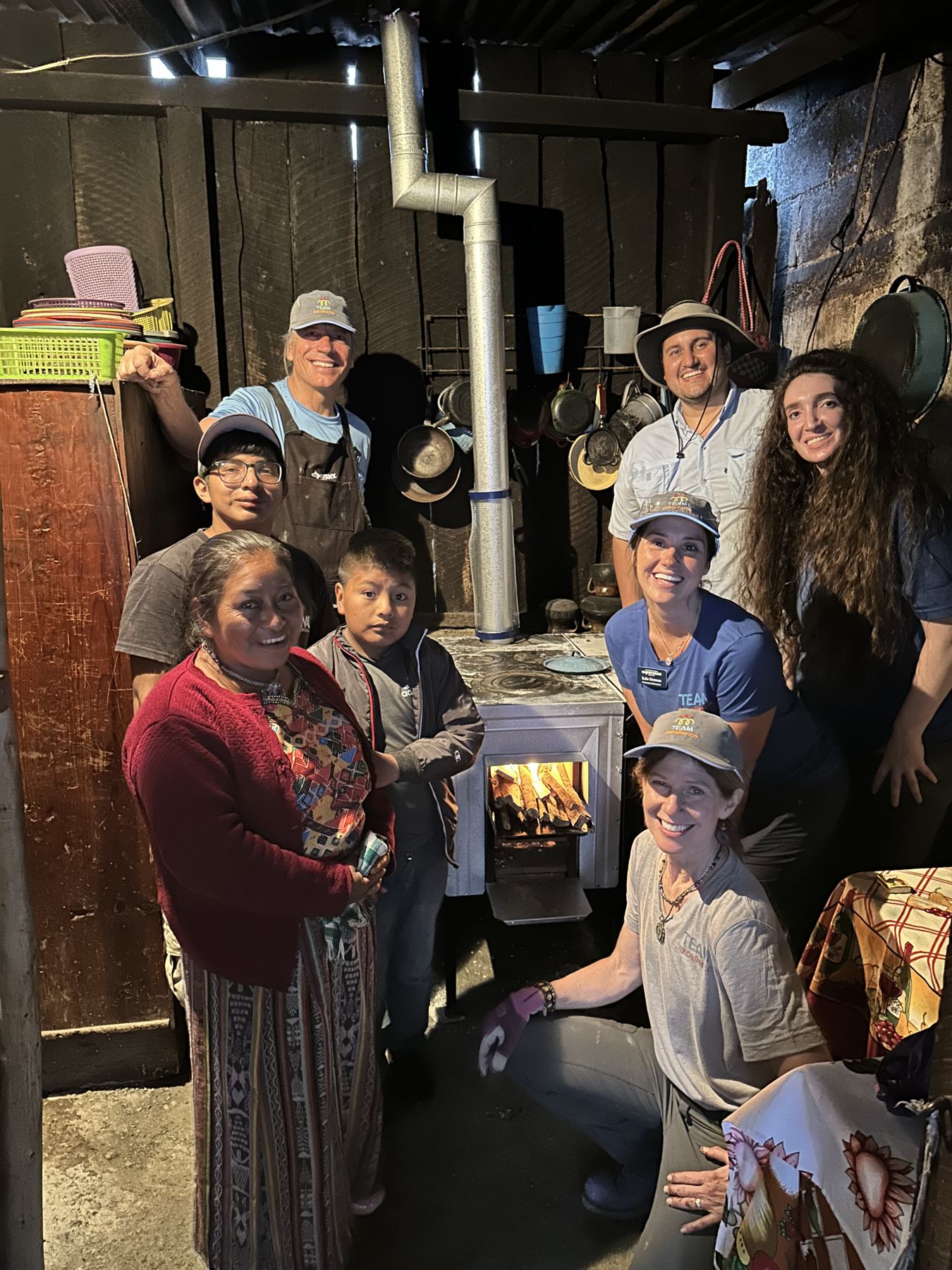 A family and volunteers gathered around a newly installed stove